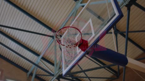 LOW-ANGLE-African-American-black-college-male-basketball-player-practicing-dunks-alone-on-the-indoor-court.-4K-UHD-120-FPS-SLOW-MOTION-RAW-Graded-footage